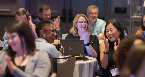 2022 Registry Summit Attendees Laughing and Clapping